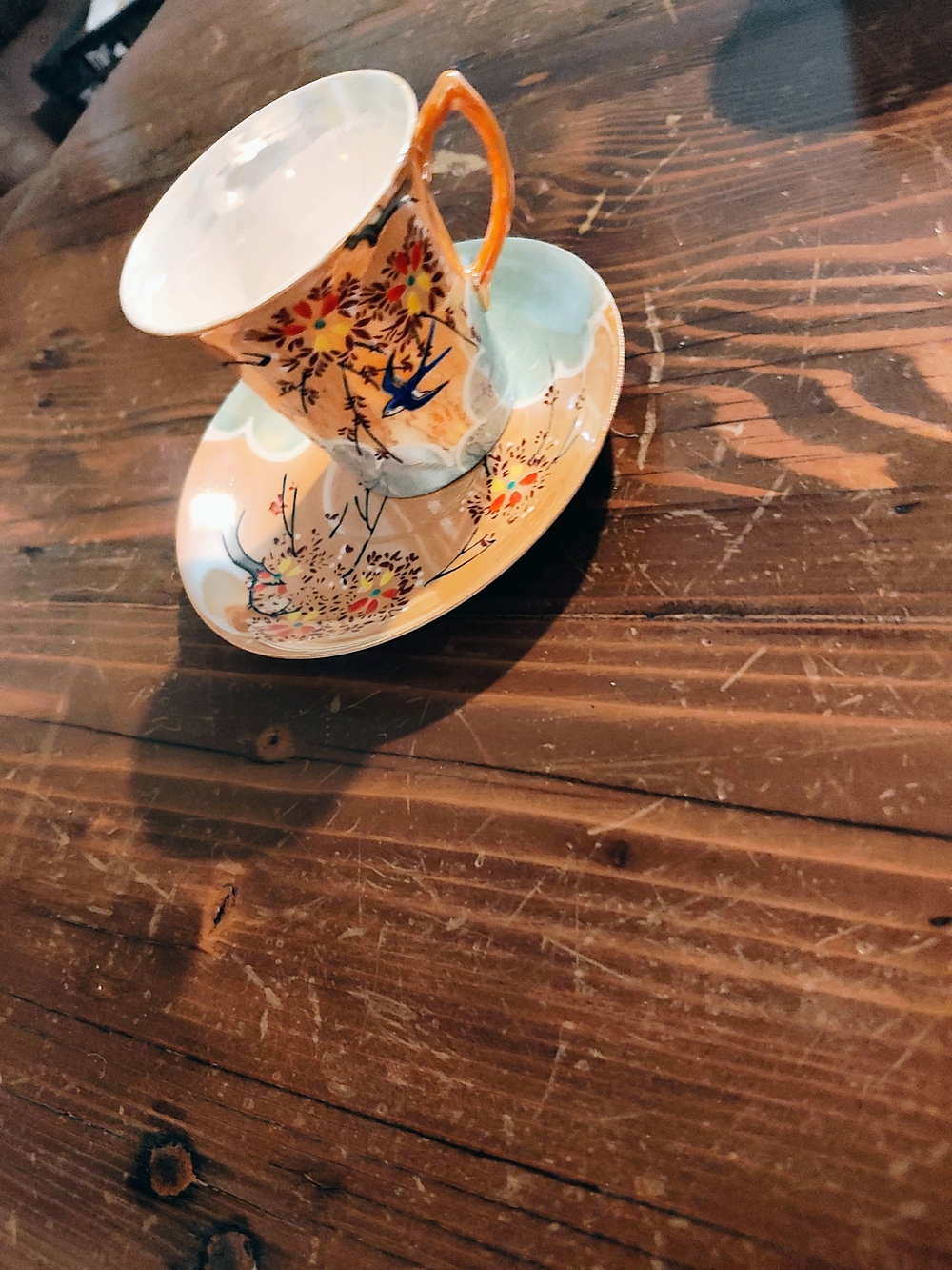 Porcelain Teacup and Saucer with Orange Handle and Floral Bird Motif
